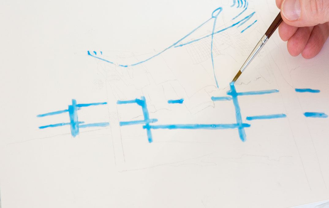 A hand painting lines on a paper with a pencil and blue colour.