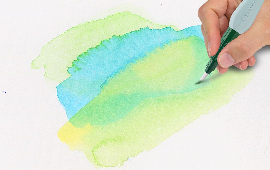 A hand mixing green and yellow colours with the watertank brush.